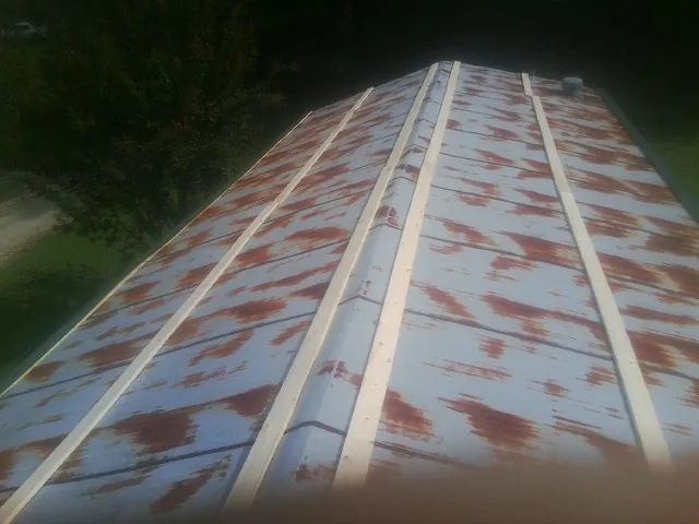 Rusted metal roof panels with new wood purlins before replacement — Storm Damage Roof Repair in Quebeck by Roofing Brothers