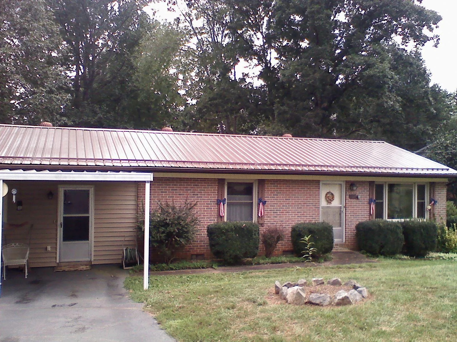 Bronze metal roof and carport on a brick ranch home — Roof Repair work by our crew in Quebeck